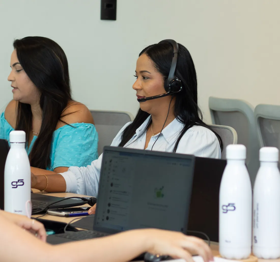 Consultora da G5 atendendo um cliente com headset