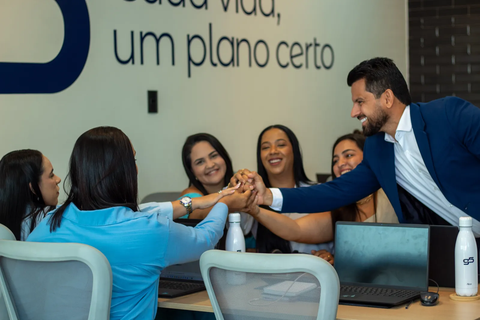 Paulo Lucena, CEO da G5, unindo as mãos com a equipe de consultoras no escritório